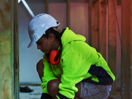 Female worker using tape measure at site.