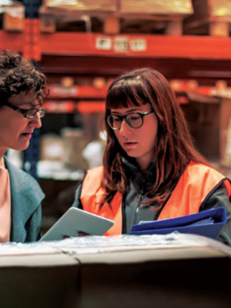 Two people in a factory looking at business solutions.