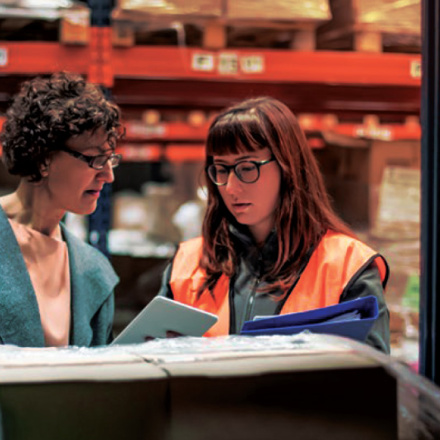 Two people in a factory looking at business solutions.