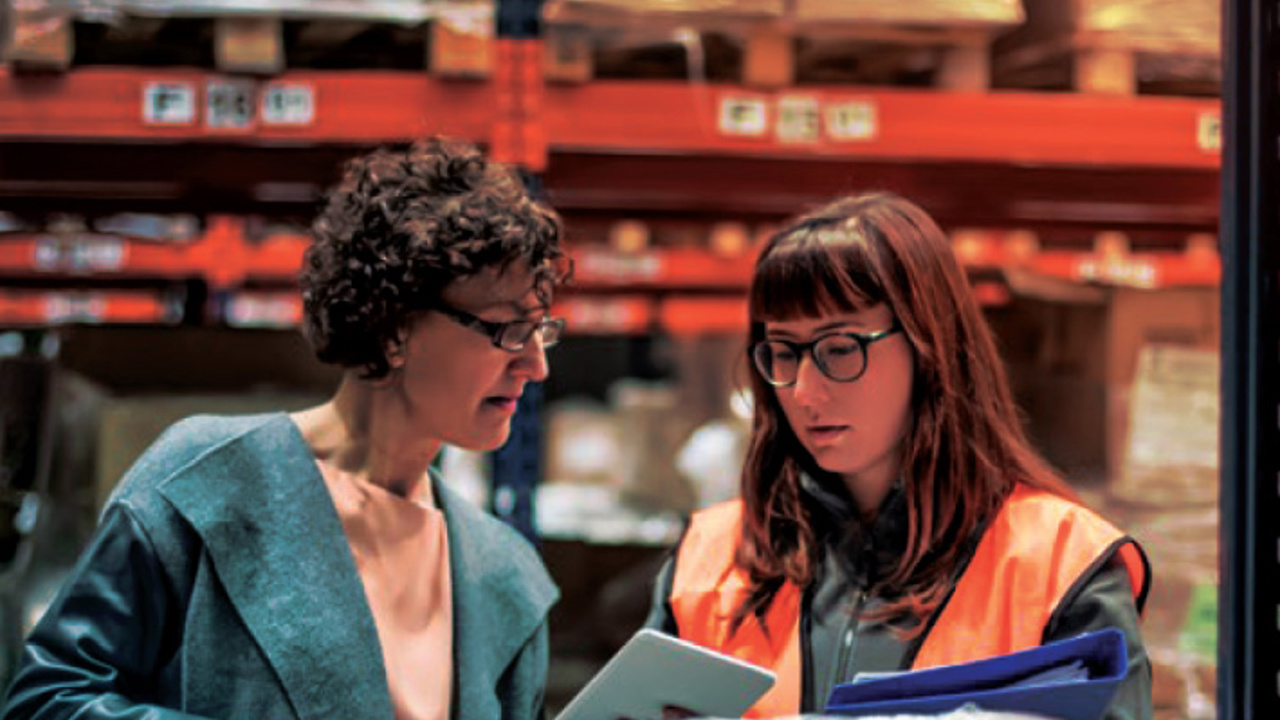 Two people in a factory looking at business solutions.