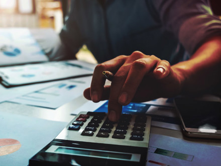 Business accounting concept, Business man using calculator with computer laptop, budget and loan paper in office.