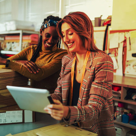 Two women looking at their ERP system on a laptop while in their store.  