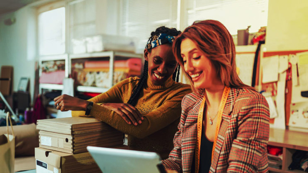 Two women looking at their ERP system on a laptop while in their store.  