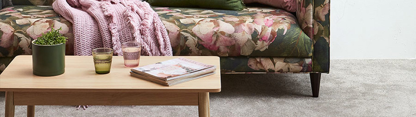 Interior shot of carpet and colourful couch. 