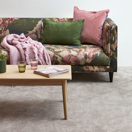 Interior shot of carpet and colourful couch. 