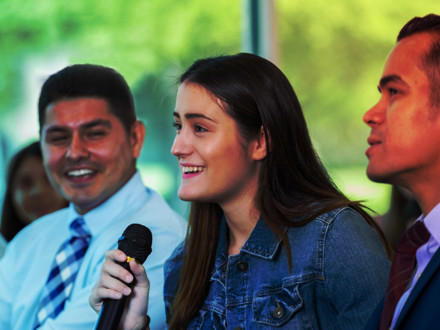 Young woman asks question during town hall meeting