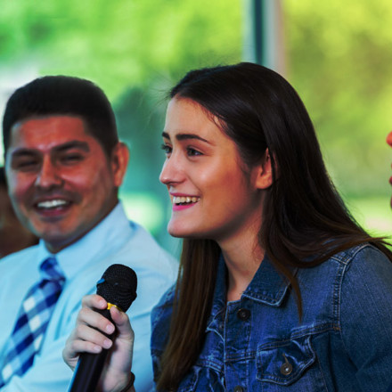 Young woman asks question during town hall meeting