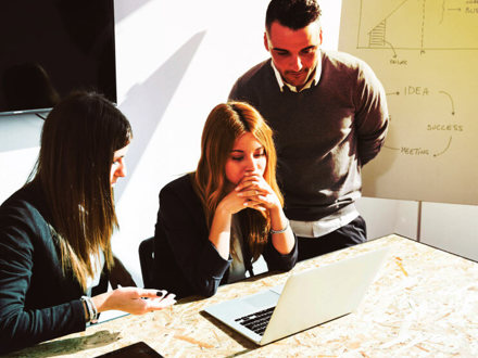 Three people strategising at a table