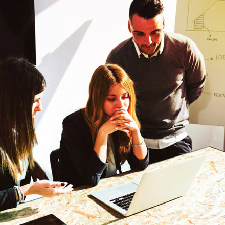 Three people strategising at a table