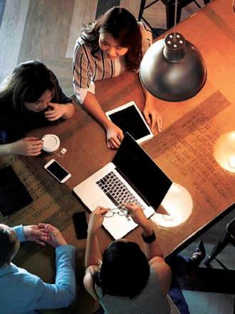 Staff sitting around a table working on their business solutions.