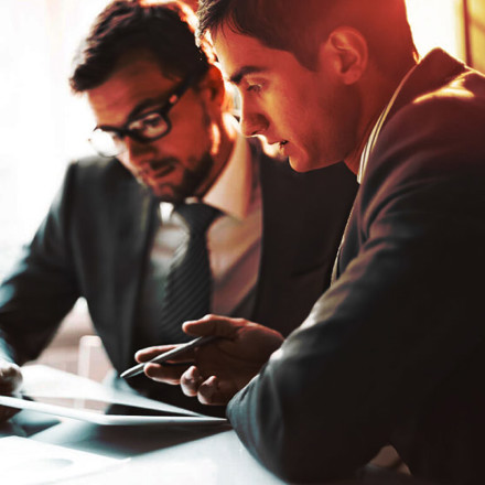 Two business men discussing something important on a tablet.