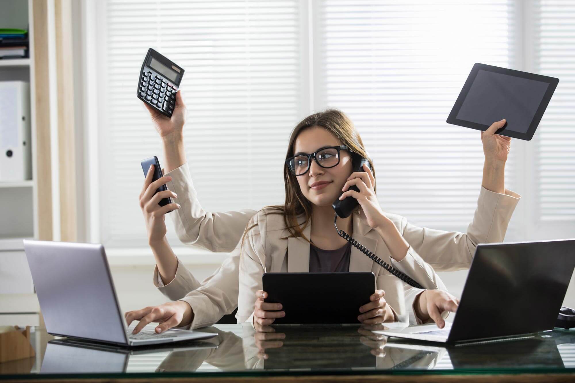 Busy Young Smiling Businesswoman With Six Arms Doing Different Type Of Work In Office.