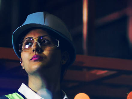 Lady with a white hard hat and safety goggles