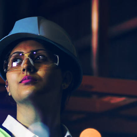 Lady with a white hard hat and safety goggles