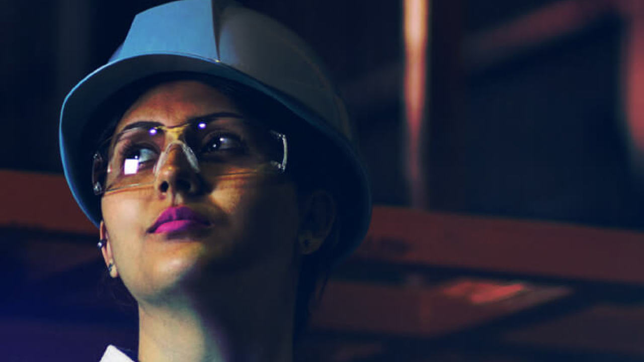 Lady with a white hard hat and safety goggles