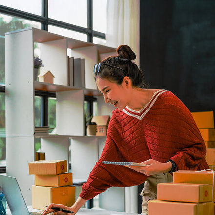 Young pretty Asian freelancer preparing product boxes for send to client, SME entrepreneur and work at home concept.