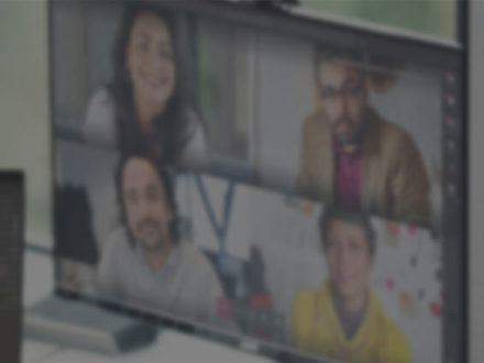 Woman speaking on a video call with a group of people. 