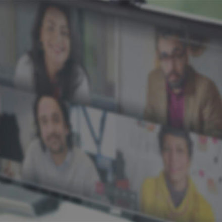 Woman speaking on a video call with a group of people. 