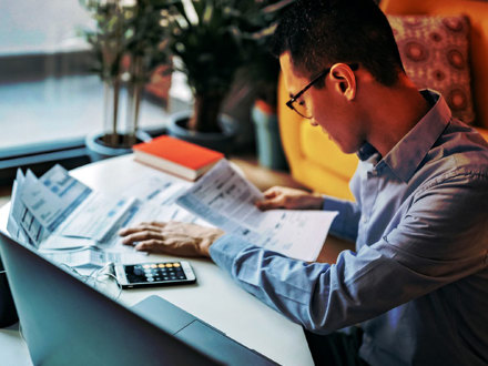 Japanese man calculating financial bills at home