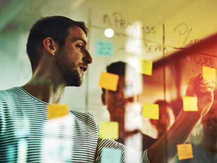 Cropped shot of a group of young designers using sticky notes during a brainstorming session