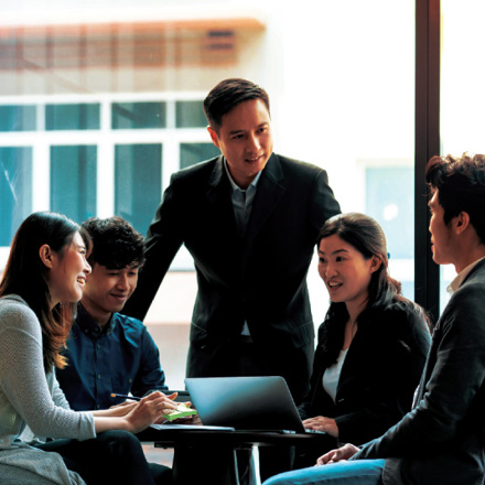 Staff in a boardroom reviewing their business solutions.