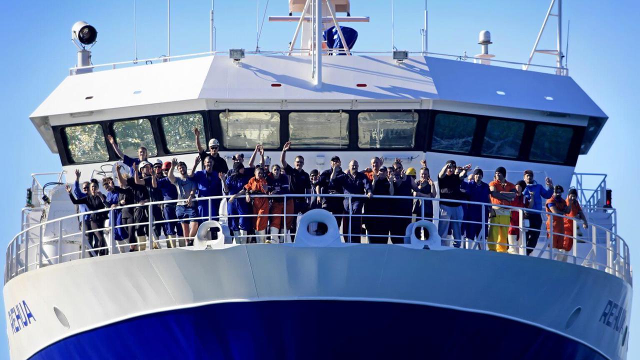 Sealord crew waving from a commercial fishing boat