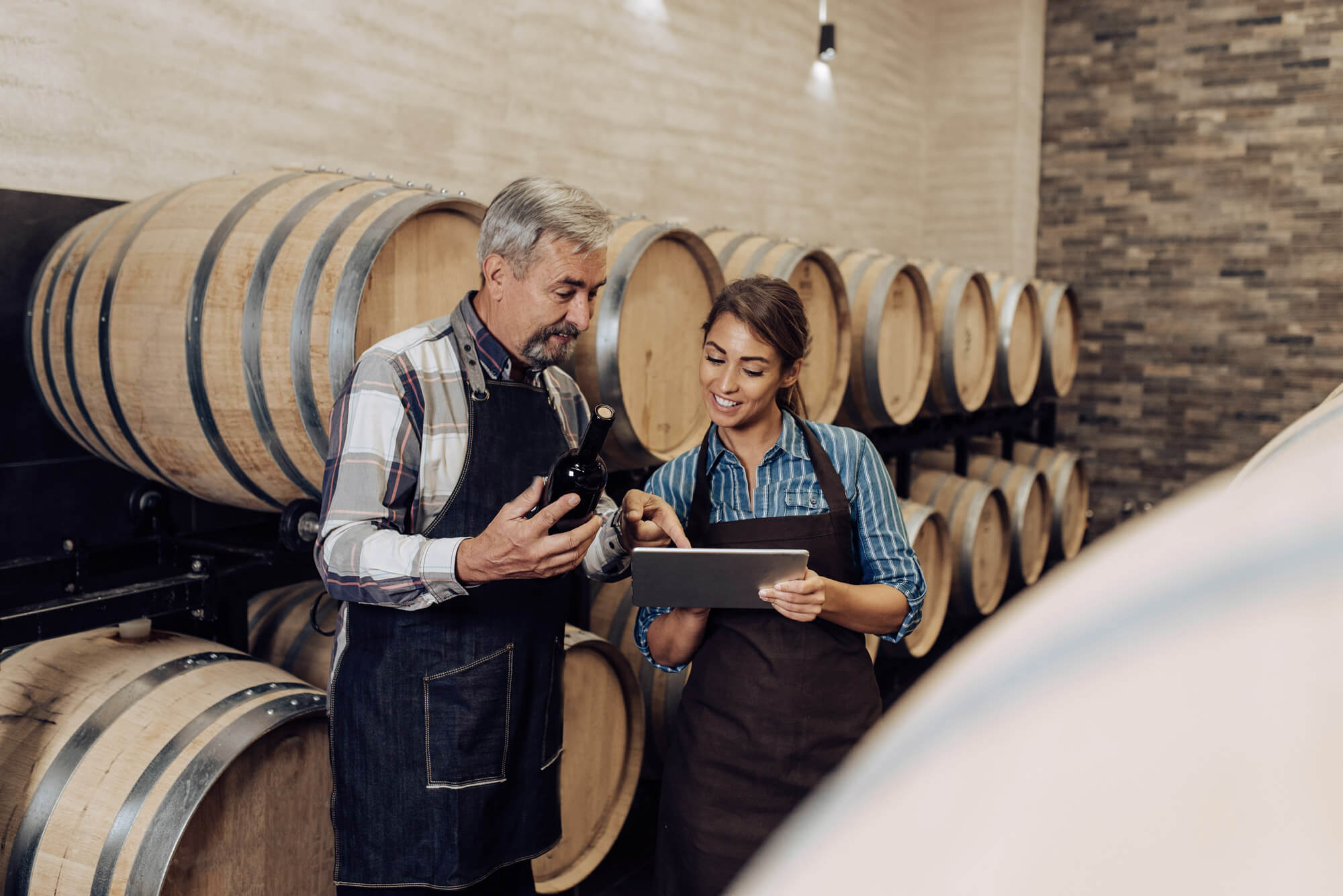 Father and daughter checking the quality of the wine at their family winery.