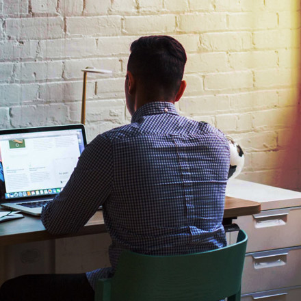 Man sitting down and using his laptop. Working from home. 