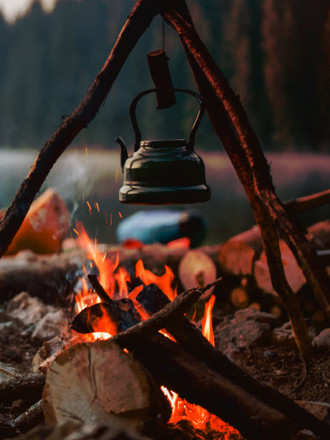 Shot of a cute vintage teapot in a campsite near to lake.