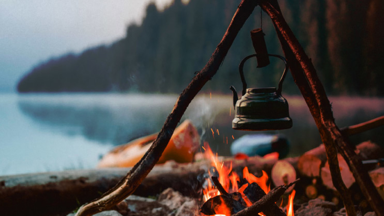 Shot of a cute vintage teapot in a campsite near to lake.