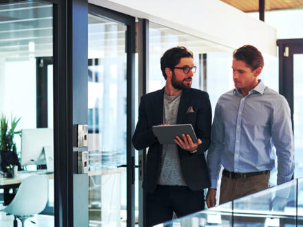 Shot of two businessmen using a digital tablet together in an office