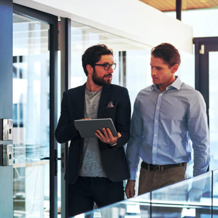 Shot of two businessmen using a digital tablet together in an office