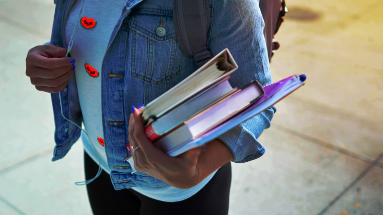 Top shot of student carrying books.