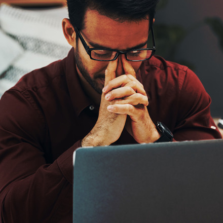 A business professional looks frustrated at his accounting software on his laptop computer