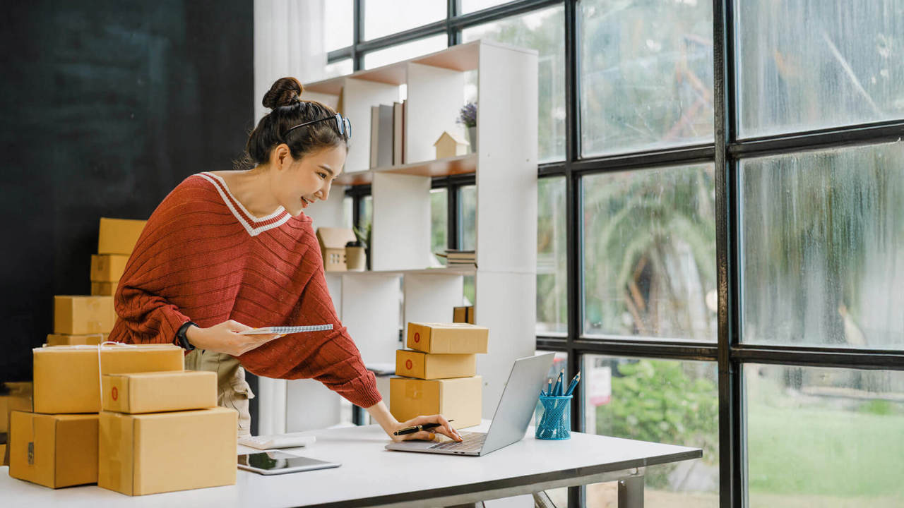 Young pretty Asian freelancer preparing product boxes for send to client, SME entrepreneur and work at home concept.