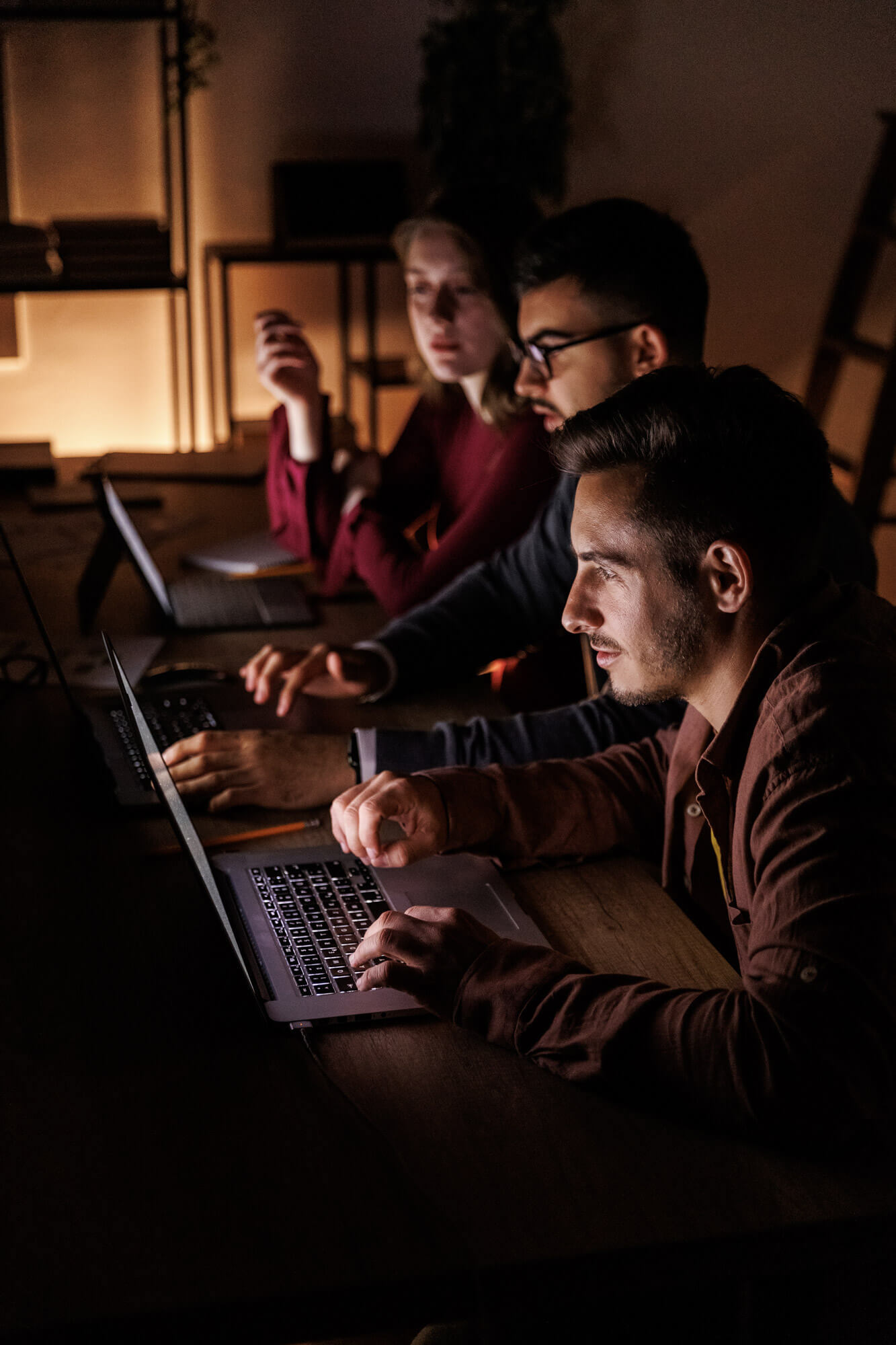 Group of entrepreneurs working as a team to finish a project late at night.