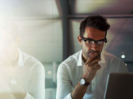 Cropped shot of a handsome young businessman looking thoughtful while working on his laptop in the office