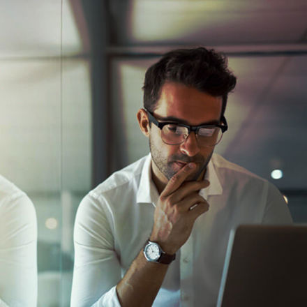 Cropped shot of a handsome young businessman looking thoughtful while working on his laptop in the office