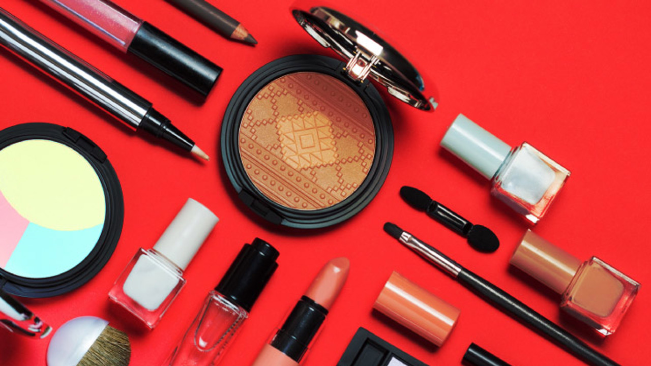 Beauty, decorative cosmetics, flat lay, top view, minimalistic style with red background.