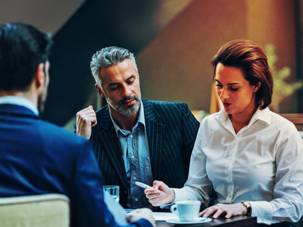 Mature businessman with his younger team looking at documents.