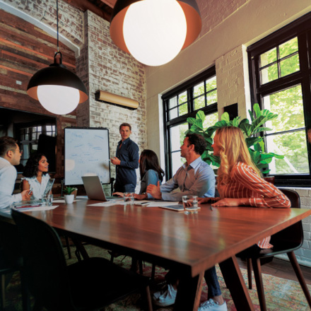 Business Solutions discussion by staff in a boardroom.