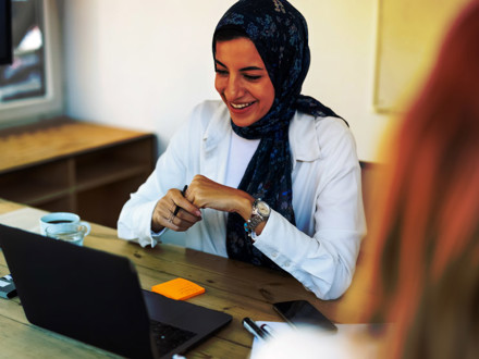 Happy middle eastern businesswoman with headscarf having video call with laptop.