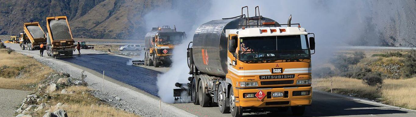 Isaac Construction trucks sealing a road