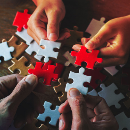 Business people Holding Jigsaw Puzzle, group of business people using a jigsaw puzzle to demonstrate the need to work in the same direction to work fully and effectively