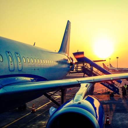 Passengers boarding an airplane at dusk.