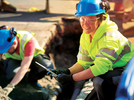 A female gas engineer holds a new gas valve as she and a colleague prepare to replace the old pipework in a residential UK street .