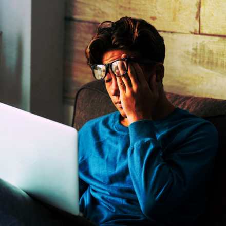 Stressed student at home studying with personal laptop computer