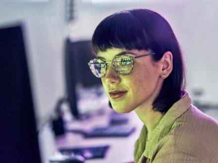 Night, reflection and neon with woman at computer for programmer, cloud computing and software developer. Coding, cybersecurity and technology with employee in digital agency for it, designer or code.