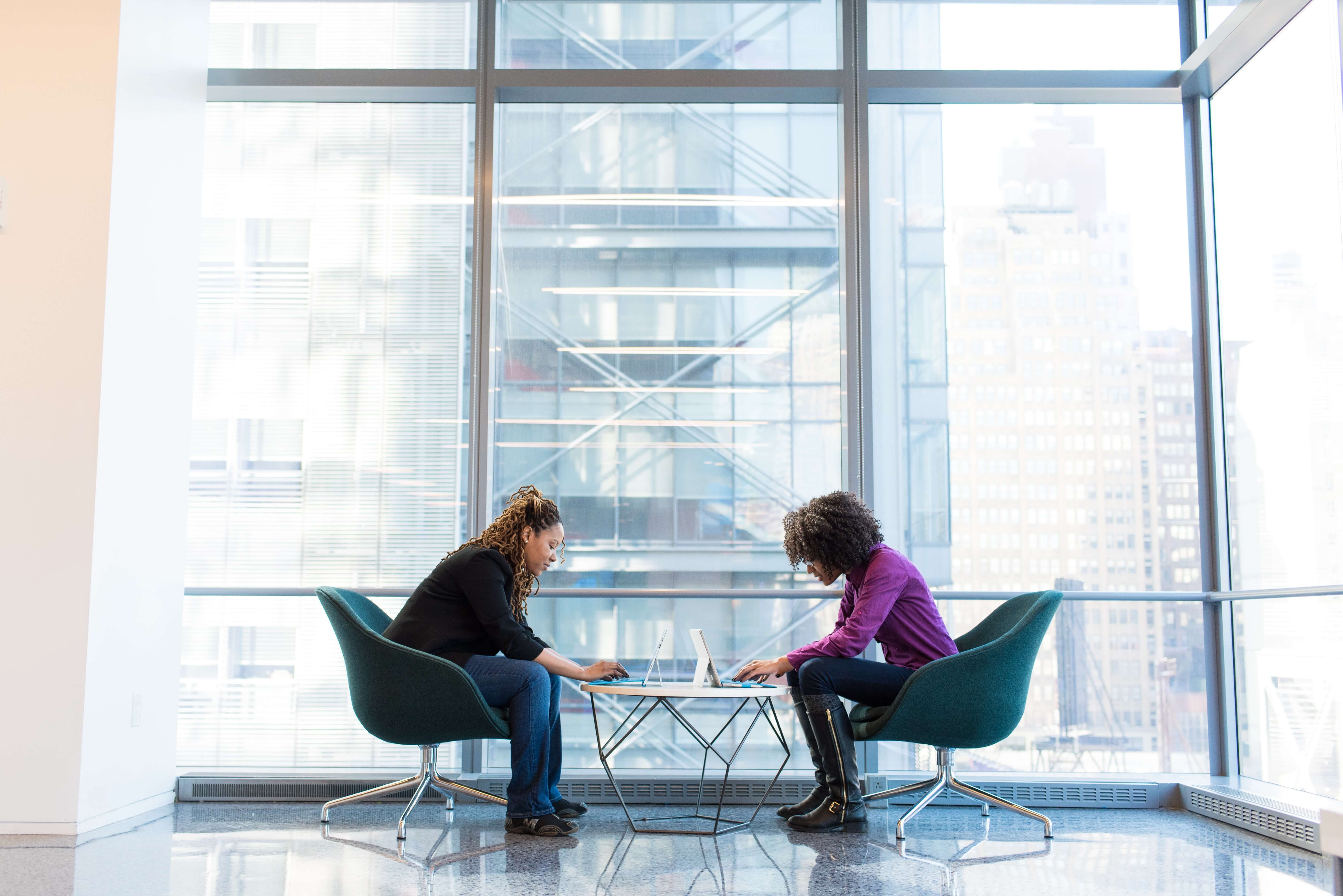 Two business people having a meeting in a communal office space